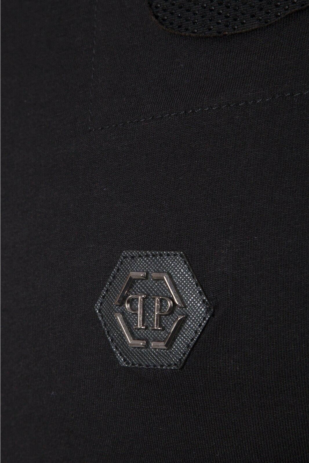 Close-up of black fabric with hexagonal textured patch and metallic PP logo